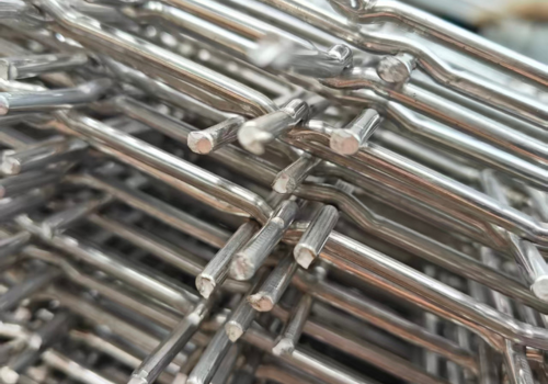 Macro shot of crimped wire mesh showing precise metal interweaving structure and durable weaving details for industrial screening applications